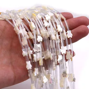 Irisierende Naturmuschel-Perlen in Bärenform für DIY-Schmuck, von Hand gehalten