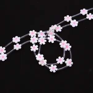 Macro view of white flower shell beads with pink centers for DIY jewelry making