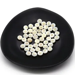 Detailed macro view of 6mm white shell beads with golden clover patterns for jewelry DIY