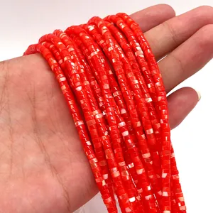 Primer plano de cuentas cilíndricas de concha natural roja con texturas de mármol