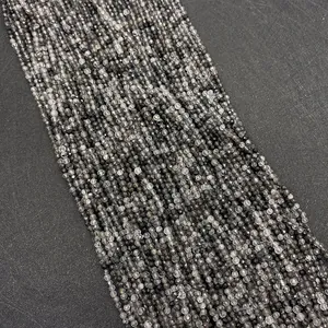 Dettaglio macro di perle sfaccettate in quarzo rutilato nero per la creazione di gioielli