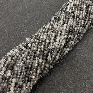 Dettaglio macro di perle sfaccettate in quarzo rutilato nero per gioielli fai da te