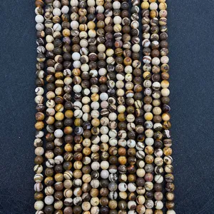 Gros plan de perles rondes en pierre de zèbre naturelle aux motifs marron et crème