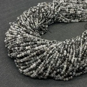 Vista macro di perle sfaccettate in quarzo rutilato nero naturale con inclusioni