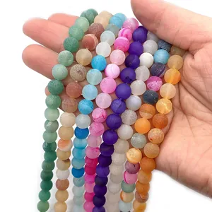 Matte natural agate beads in mixed colors held by hand for jewelry DIY accessories