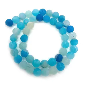 Macro view of matte natural striped agate beads in gradient blue shades for DIY jewelry