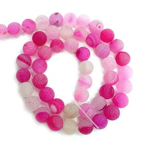 Macro detail of matte natural striped agate beads in pink hues for DIY jewelry making