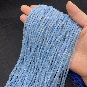 Detailed view of 3-4mm faceted light blue apatite round beads with dark blue tassel