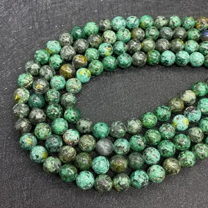 Macro detail of natural African turquoise round beads showing green and black mineral veins