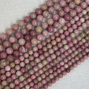 Macro view of natural round rhodonite stone beads with unique pink and grey textures