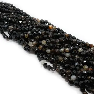 Macro detail of faceted black onyx gemstone beads showing precision cuts and natural luster