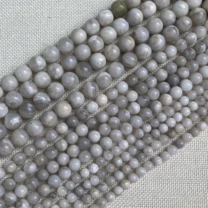 Macro shot of natural stone beads in various sizes on a beige textured fabric
