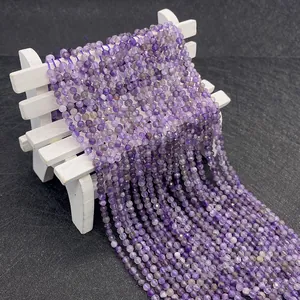 Macro detail of faceted purple amethyst beads on a white miniature display stand