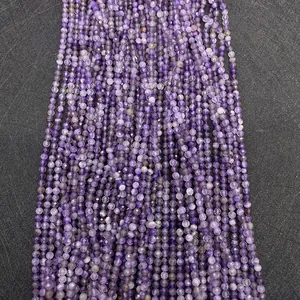 Macro view of purple faceted amethyst round beads on a dark textured background