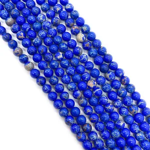 Detailed macro shot of blue Imperial Jasper round beads with golden marble texture