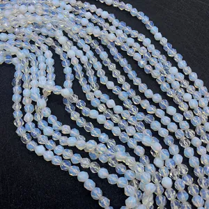 Nahaufnahme facettierter Opalperlen mit milchig weißer Textur und blauem Glanzlicht