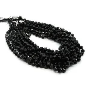Detailed macro shot of faceted black onyx gemstone beads showing diamond cut texture