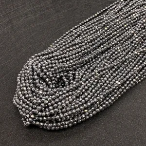 Vista macro di perline di ematite sfaccettate da 2-3mm in grigio scuro metallico per DIY