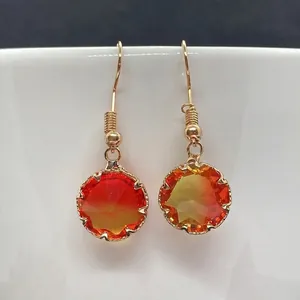 Detailansicht der Goldohrringe mit facettierten orange-gelben Kristallsteinen im Verlauf
