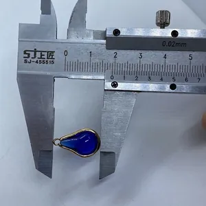 Detailmessung eines blauen Tropfenanhängers mit Goldrand mittels eines Messschiebers
