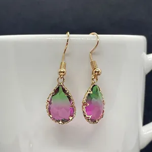 Detailaufnahme von facettierten Tropfenohrringen mit pink-grünem Farbverlauf und Gold