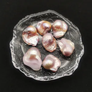 Makroaufnahme von sieben violetten Barockperlen mit Metallglanz in einer Glasschale