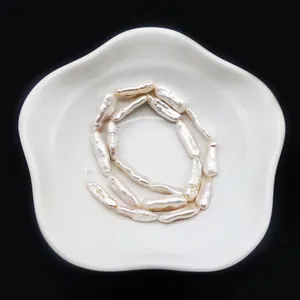 Vista macro di perle barocche bianche naturali con lucentezza su un piatto di ceramica
