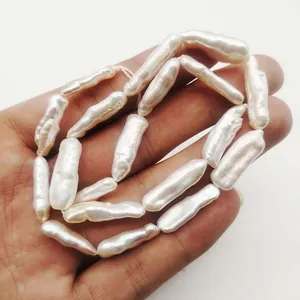 Perle d'acqua dolce barocche bianche naturali in forma allungata con forte lucentezza nel palmo