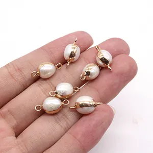 Detailed view of natural freshwater baroque pearl connectors with gold-plated edges in hand