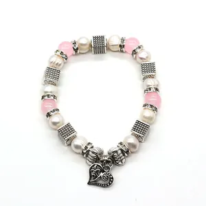 Bracciale di perle rosa e bianche con un ciondolo a cuore in argento traforato