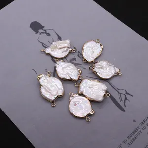 Détails macro de pendentifs en perles baroques avec bord doré et doubles anneaux de saut