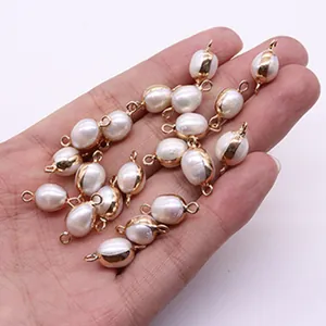 Irregular freshwater pearl pendant with gold plating and double loops held by hand