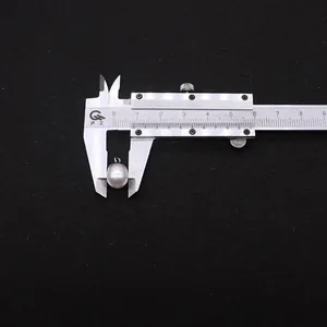 Macro shot measuring 9x15mm oval freshwater pearl pendant with a metal vernier caliper