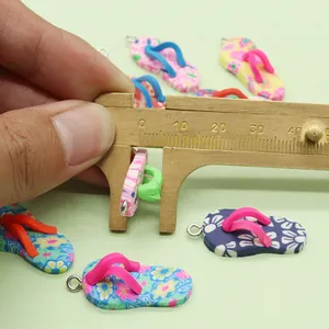 Macro shot measuring colorful polymer clay flip flop pendant with a wooden caliper tool