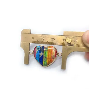 Macro view of a 31mm rainbow stone heart connector charm with gold metal edges