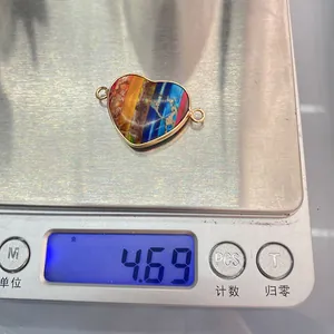 Macro shot of a heart-shaped gemstone connector with gold trim on a digital scale