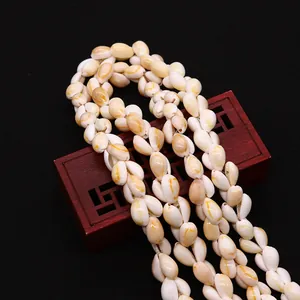 Detail of natural cowrie shell beads on red vintage jewelry box for DIY crafts