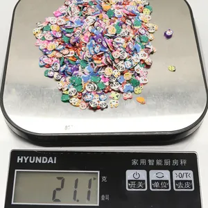 Macro detail of colorful clay animal beads being weighed on a digital scale for DIY crafts