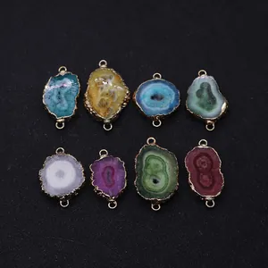 Macro view of irregular natural stone pendants with gold-plated edges and dual metal loops