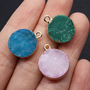 Makroaufnahme von Druzy-Kristallanhängern in Grün, Blau und Rosa mit Goldrand-Detail