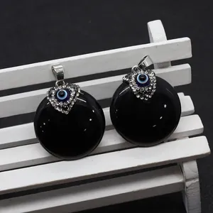 Close-up of black onyx evil eye charms with blue pupils and sparkling white rhinestones