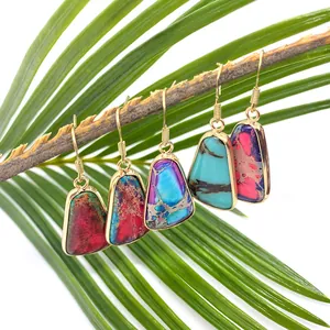 Bohemian style natural stone teardrop earrings hanging on a branch with green leaves