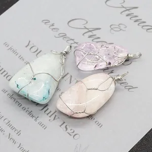 Macro-opname van onregelmatige natuurstenen omwikkeld met zilverdraad voor sieraden
