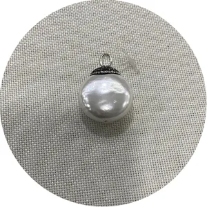Flat round white shell pendant with micro-pave crystals and silver bail on grey background