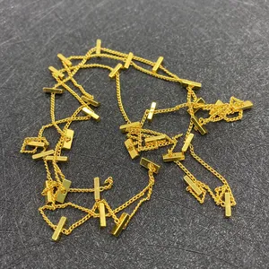 Detail einer goldenen Rechteckperlen-Gliederkette für DIY-Schmuck auf Texturhintergrund