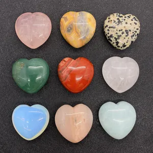 Set of 9 polished heart-shaped natural gemstones in various colors on black background