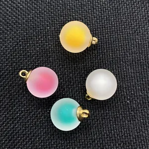 Dettaglio di ciondoli tondi in acrilico opaco da 16mm in colori misti con anelli dorati