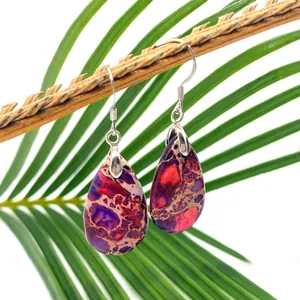 Handmade drop earrings with teardrop purple stone and silver hooks on green leaf