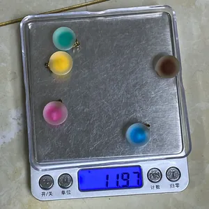 Cinque ciondoli a sfera in acrilico opaco da 16mm su una bilancia digitale pesanti 11,97g