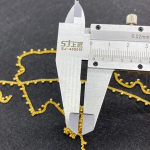 Macro view measuring a 2mm gold bead chain with a caliper for DIY jewelry making